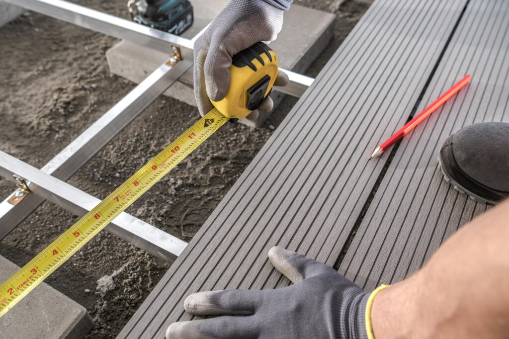 Pomiar podczas montowania tarasu z desek kompozytowych.
