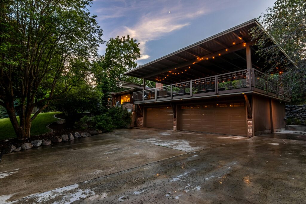 Szeroki, zadaszony taras nad podwójnym garażem.