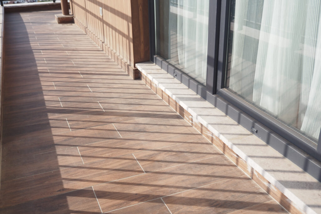 Zabudowa boku domu z płytek tarasowych imitujących drewno.